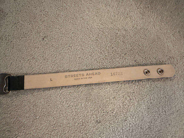 Leather belt with 'Streets Ahead' branding on a textured surface